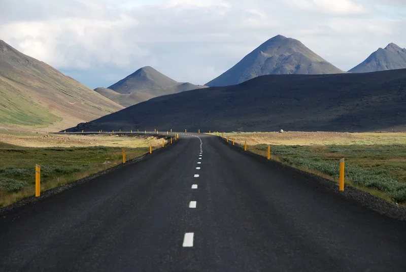 山に向かってまっすぐ延びる舗装道路の写真